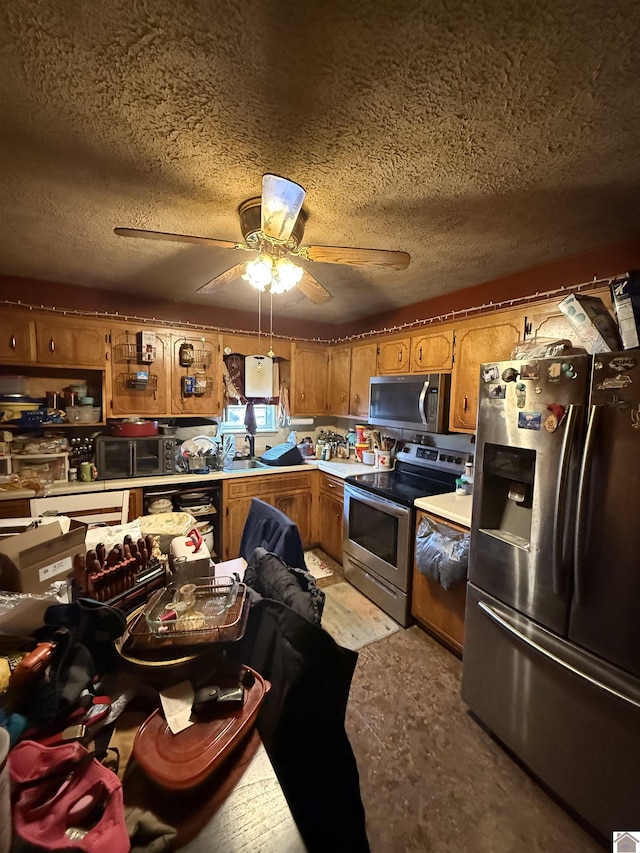 kitchen with stainless steel appliances, ceiling fan, and a textured ceiling