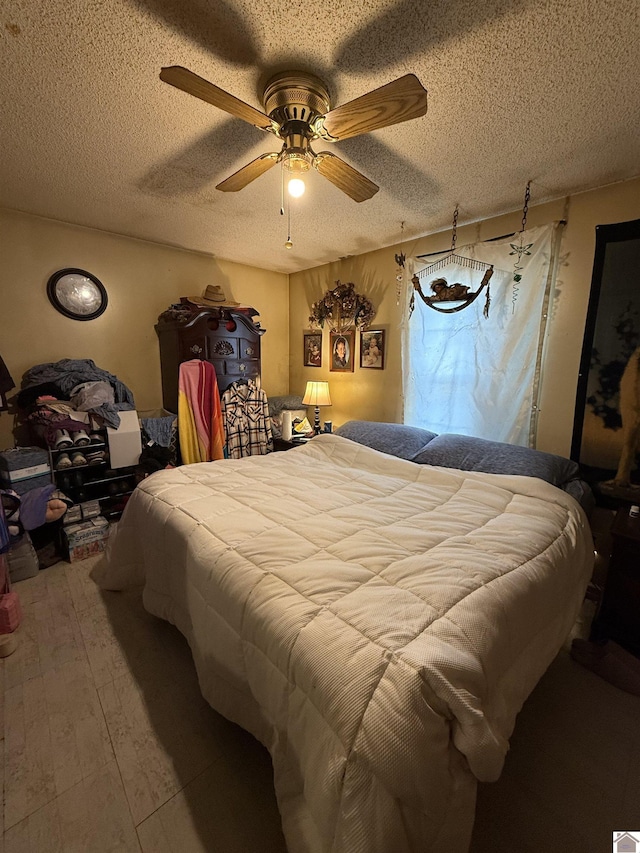 bedroom featuring wood-type flooring, ceiling fan, and a textured ceiling