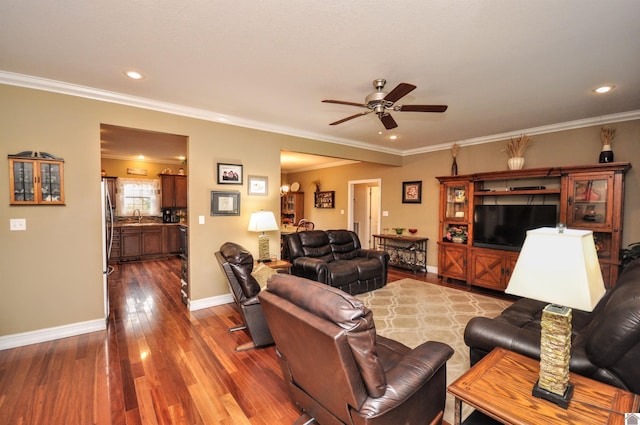 living room with hardwood / wood-style flooring, ceiling fan, crown molding, and sink