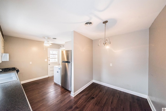 kitchen featuring an inviting chandelier, stainless steel fridge, dark hardwood / wood-style flooring, and sink