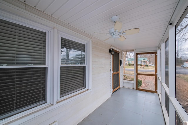 unfurnished sunroom with ceiling fan