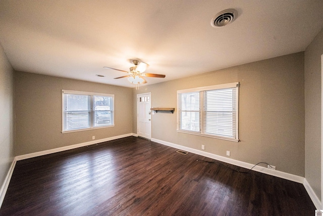 spare room featuring dark wood-type flooring and ceiling fan