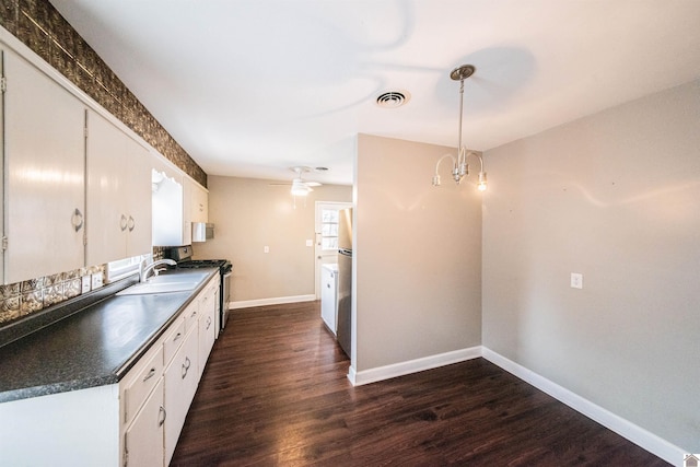 kitchen featuring sink, white cabinetry, decorative light fixtures, dark hardwood / wood-style floors, and stainless steel appliances