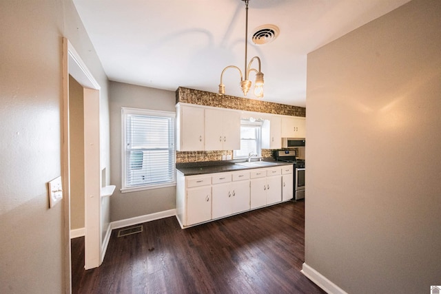 kitchen with stainless steel gas range, dark hardwood / wood-style flooring, pendant lighting, decorative backsplash, and white cabinets