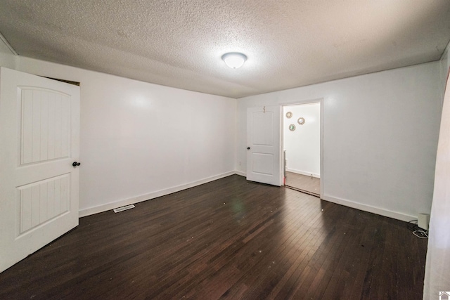 unfurnished room with dark wood-type flooring and a textured ceiling