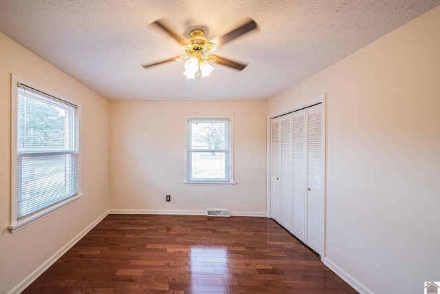 8200 Houser Rd, Boaz, Mccracken, KY 42027 - unfurnished bedroom with a closet, dark hardwood / wood-style floors, multiple windows, and a textured ceiling