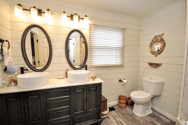 bathroom with crown molding, wood-type flooring, toilet, and vanity