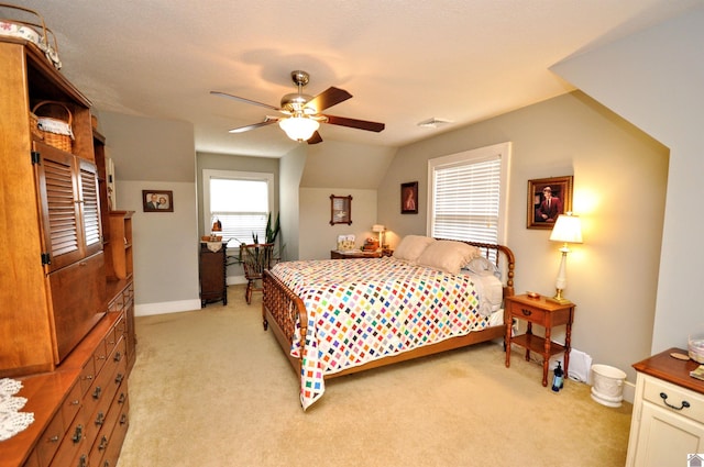 bedroom with light carpet, vaulted ceiling, and ceiling fan