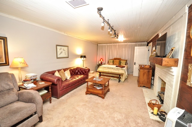 living room featuring crown molding, light colored carpet, a fireplace, and rail lighting