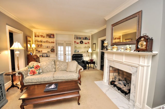 living room featuring french doors, ornamental molding, a fireplace, and built in shelves