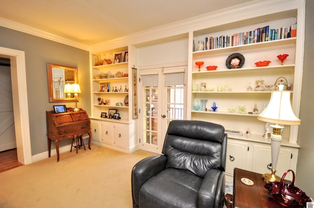 sitting room with crown molding, built in features, and light colored carpet