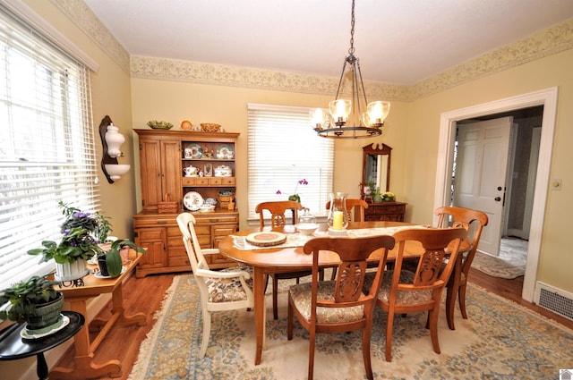 dining space with a chandelier and light wood-type flooring