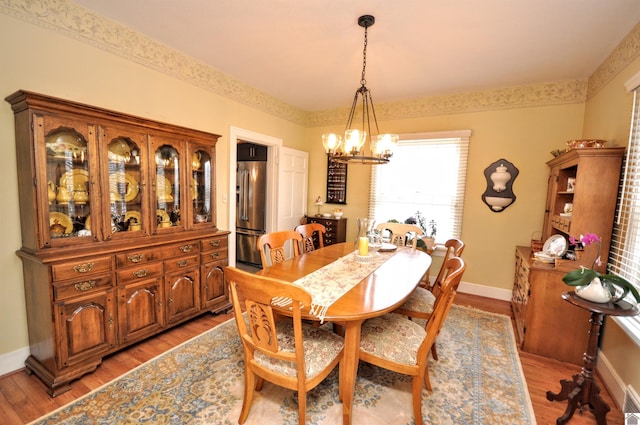 dining space with a notable chandelier and light wood-type flooring