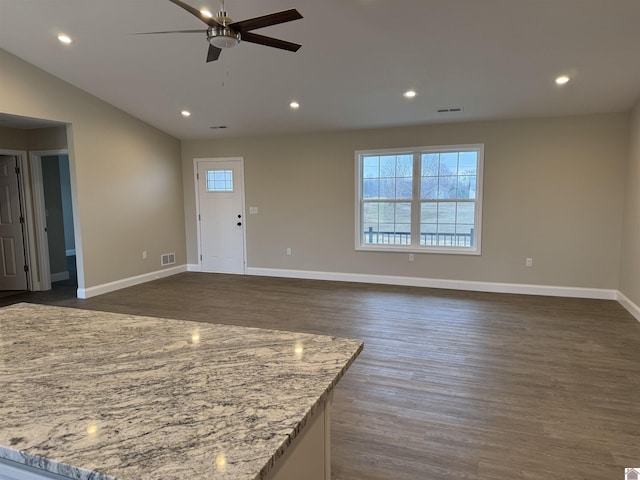 unfurnished living room featuring lofted ceiling, dark hardwood / wood-style flooring, and ceiling fan