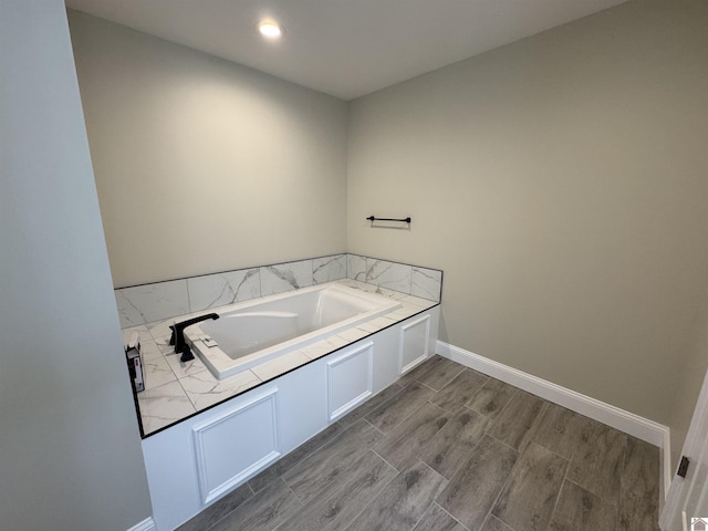 bathroom featuring wood-type flooring and a tub