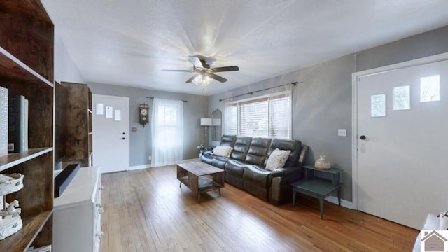 living room featuring wood-type flooring and ceiling fan