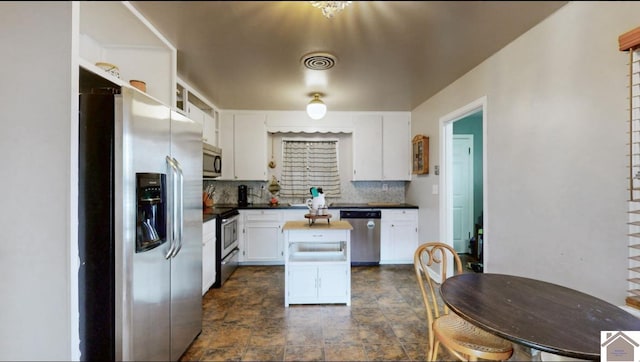 kitchen featuring backsplash, stainless steel appliances, and white cabinets