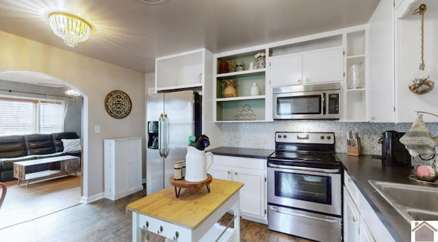 kitchen with stainless steel appliances, wooden counters, decorative backsplash, and white cabinets