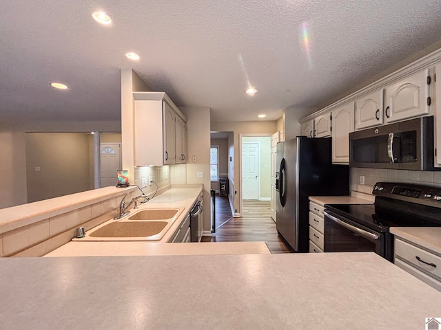 kitchen with sink, white cabinetry, tasteful backsplash, dark hardwood / wood-style floors, and stainless steel appliances