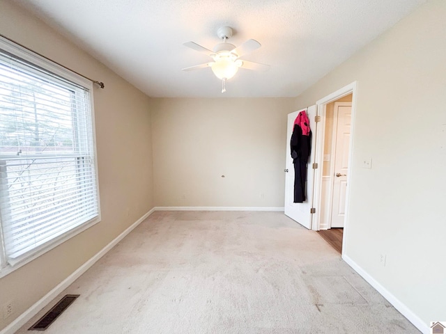 unfurnished bedroom with light colored carpet and ceiling fan