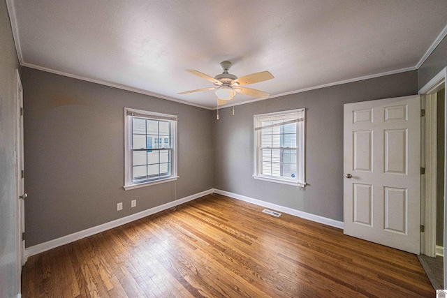 unfurnished bedroom with ceiling fan, ornamental molding, and wood-type flooring