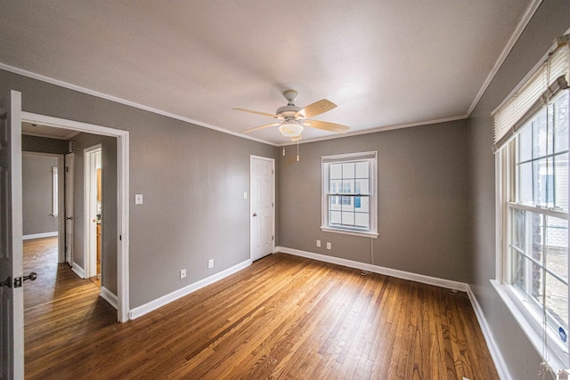 unfurnished room featuring hardwood / wood-style flooring, ceiling fan, crown molding, and a wealth of natural light