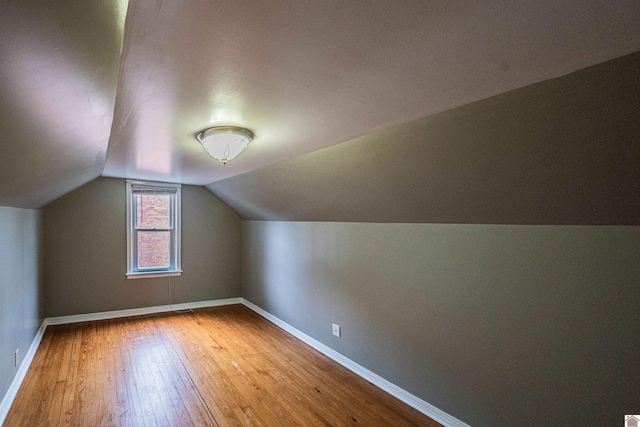 bonus room with wood-type flooring and vaulted ceiling