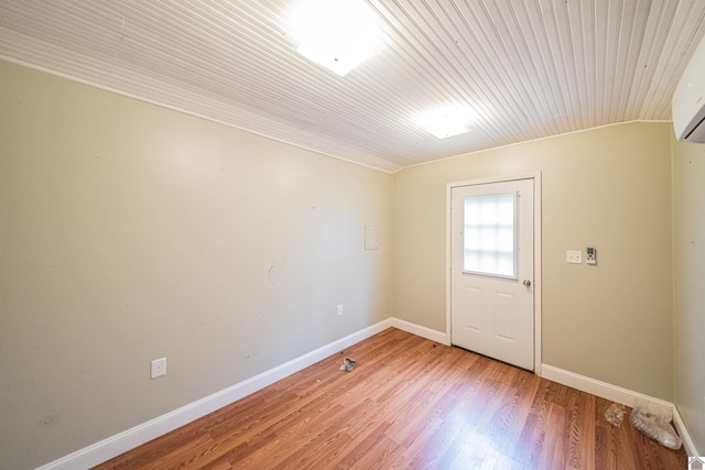 spare room with hardwood / wood-style floors and a wall mounted air conditioner