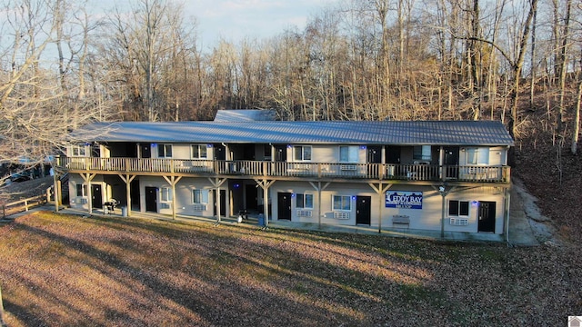 rear view of property with a yard, a deck, and a patio area