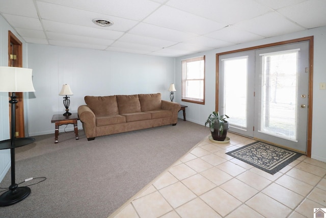 living room with light carpet and a drop ceiling