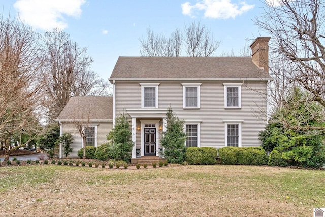 colonial inspired home featuring a front lawn