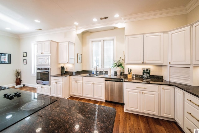 kitchen with appliances with stainless steel finishes, sink, and white cabinets