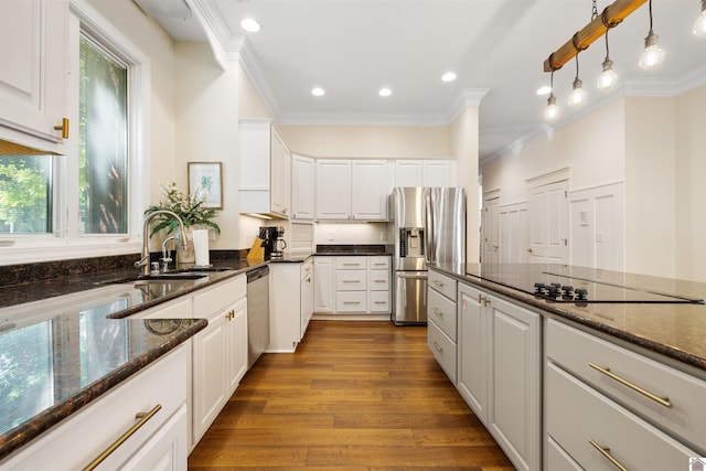 502 N 5th St, Paducah, KY 42001 - kitchen featuring appliances with stainless steel finishes, white cabinets, ornamental molding, a sink, and wood finished floors