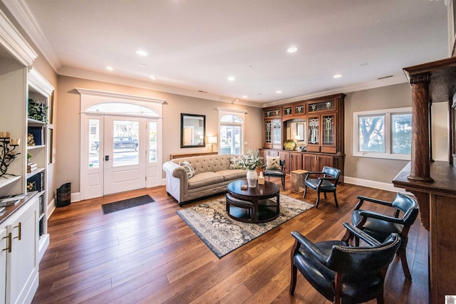 living room with dark wood-type flooring, ornamental molding, and decorative columns