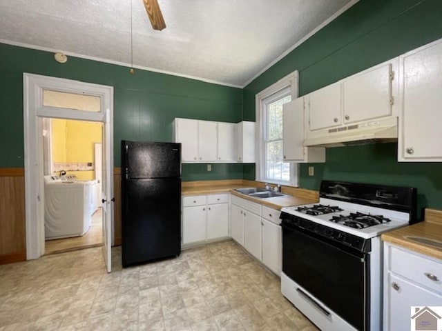 kitchen with sink, ceiling fan, black refrigerator, gas stove, and white cabinets