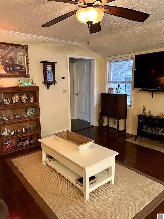 living room featuring lofted ceiling, hardwood / wood-style flooring, ceiling fan, ornamental molding, and a textured ceiling