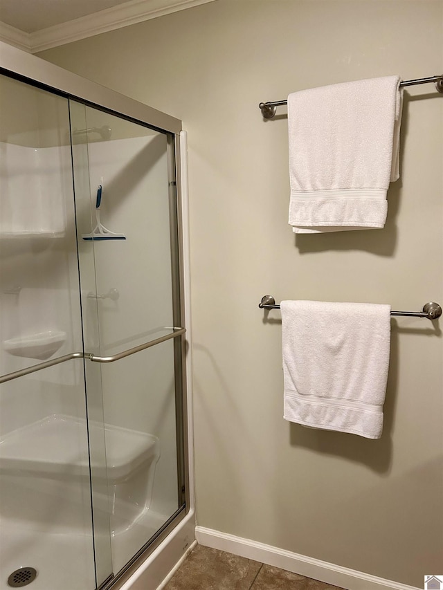 bathroom with crown molding, tile patterned flooring, and walk in shower