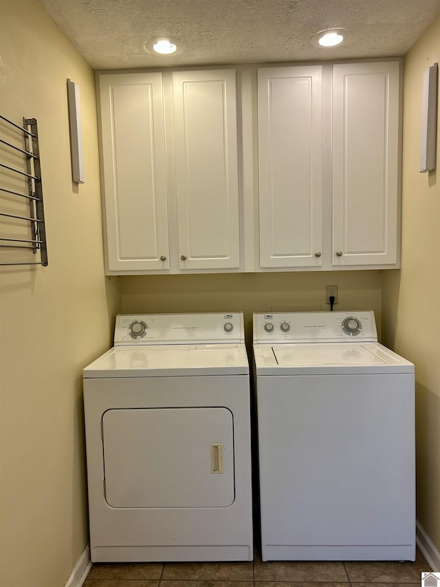 clothes washing area featuring cabinets, separate washer and dryer, and a textured ceiling