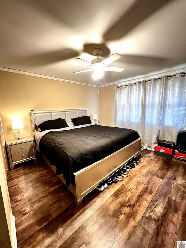 bedroom with dark wood-type flooring, ornamental molding, and ceiling fan