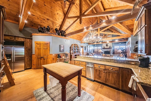 kitchen with stainless steel refrigerator with ice dispenser, light wood-type flooring, wooden ceiling, and light stone counters