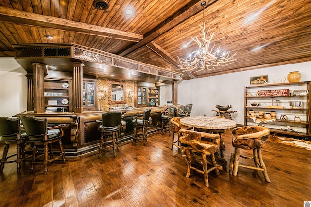 dining area with indoor bar, dark hardwood / wood-style flooring, lofted ceiling with beams, and wooden ceiling