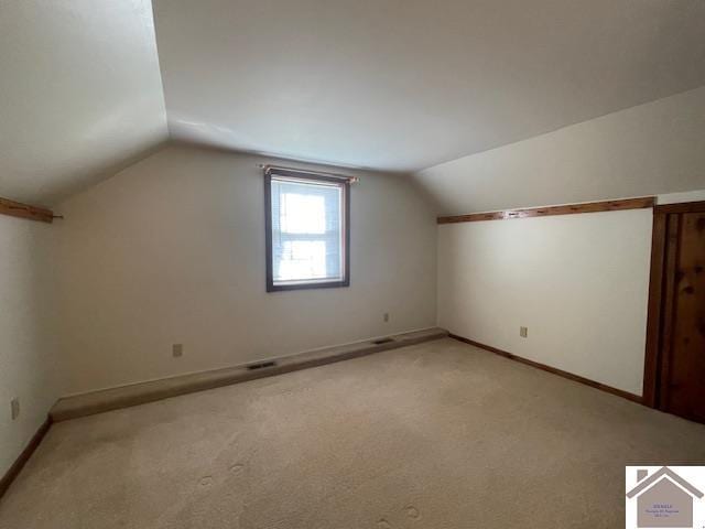 bonus room featuring vaulted ceiling and light carpet