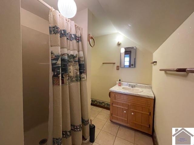 bathroom with vanity, vaulted ceiling, tile patterned floors, and walk in shower