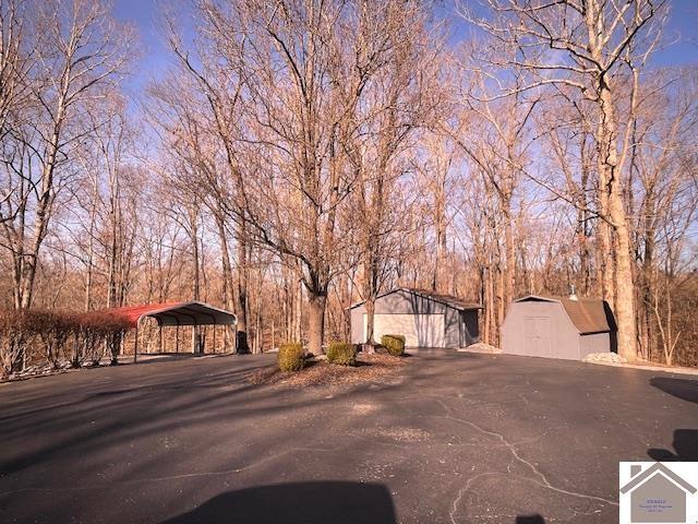 view of front of home with a carport and a storage unit