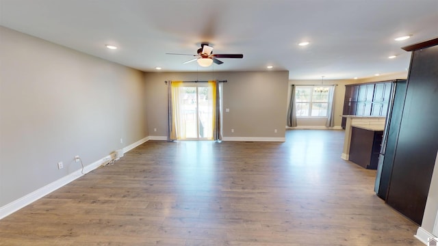 2206 Traci Dr, Murray, KY 42071 - unfurnished living room with baseboards, wood finished floors, and ceiling fan with notable chandelier
