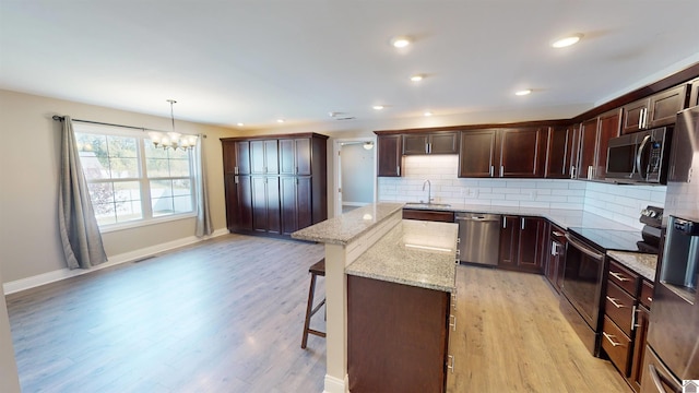 2206 Traci Dr, Murray, KY 42071 - kitchen with stainless steel appliances, a center island, a kitchen breakfast bar, a sink, and a chandelier