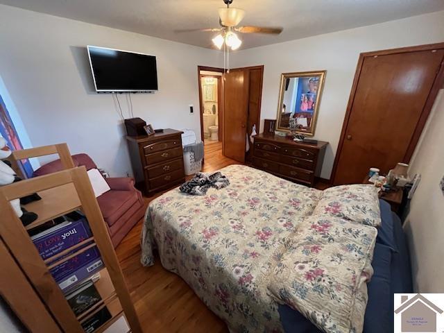 bedroom featuring hardwood / wood-style floors, ceiling fan, and ensuite bathroom