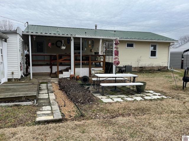 rear view of property with a wooden deck, a yard, and central air condition unit