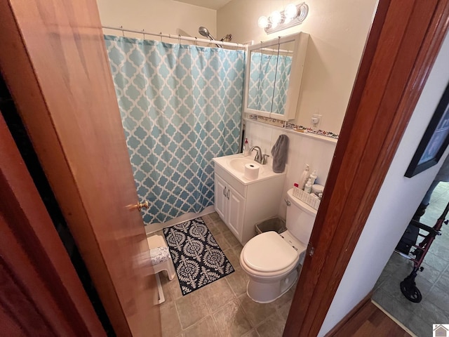 bathroom with a shower with curtain, vanity, toilet, and tile patterned flooring