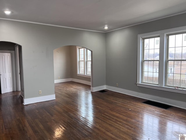 spare room featuring ornamental molding and dark hardwood / wood-style floors